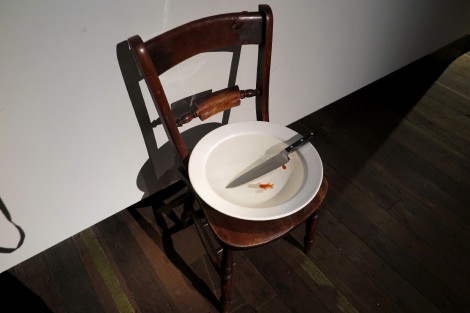 Stuhl mit Teller, Messer und zwei lebenden Goldfischen